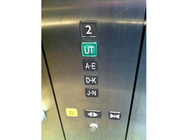 Three buttons in a parking garage elevator are marked A-E, D-K and J-N